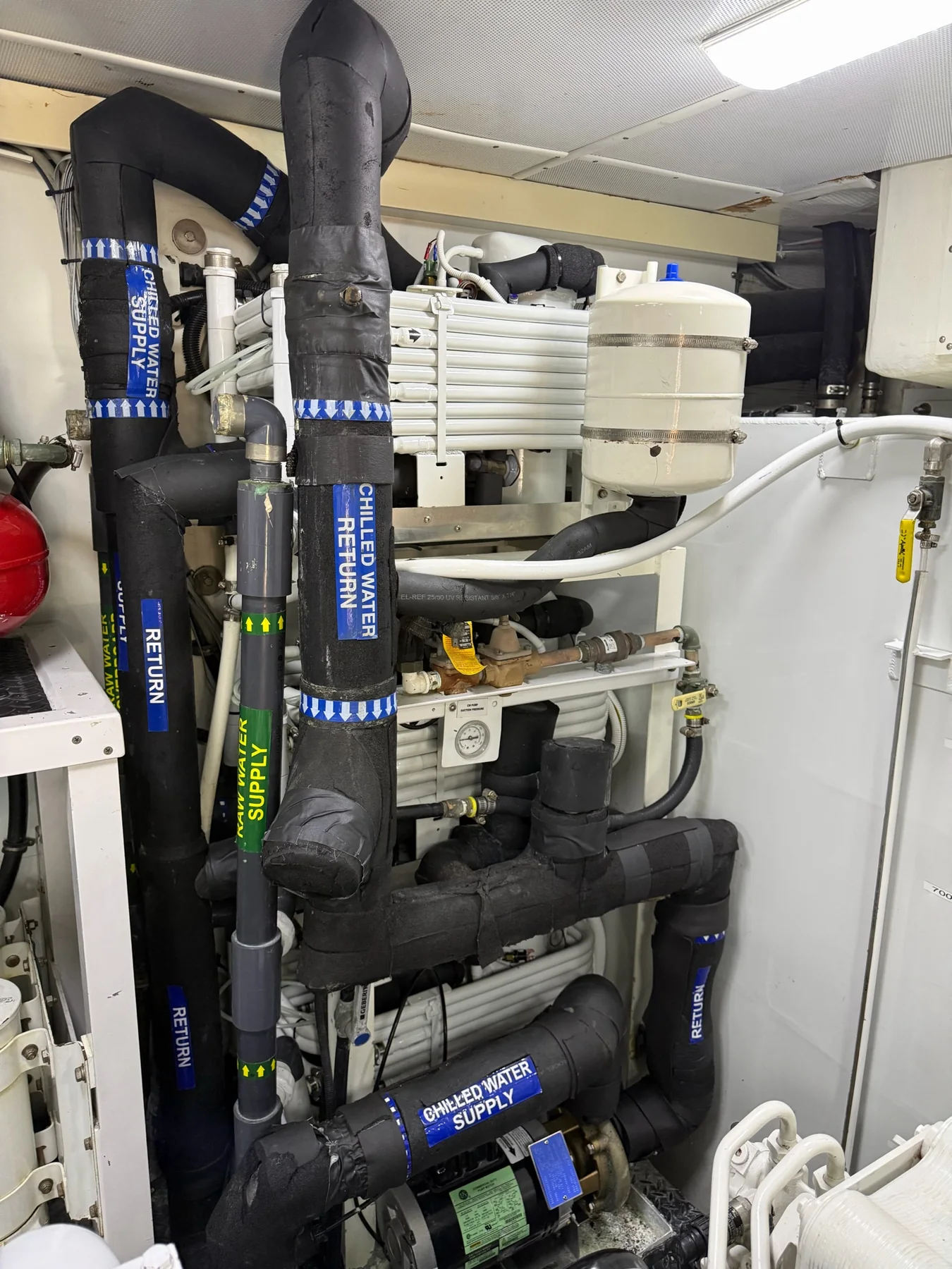 Marine chilled-water piping, pump, expansion tank, and labeled supply and return lines