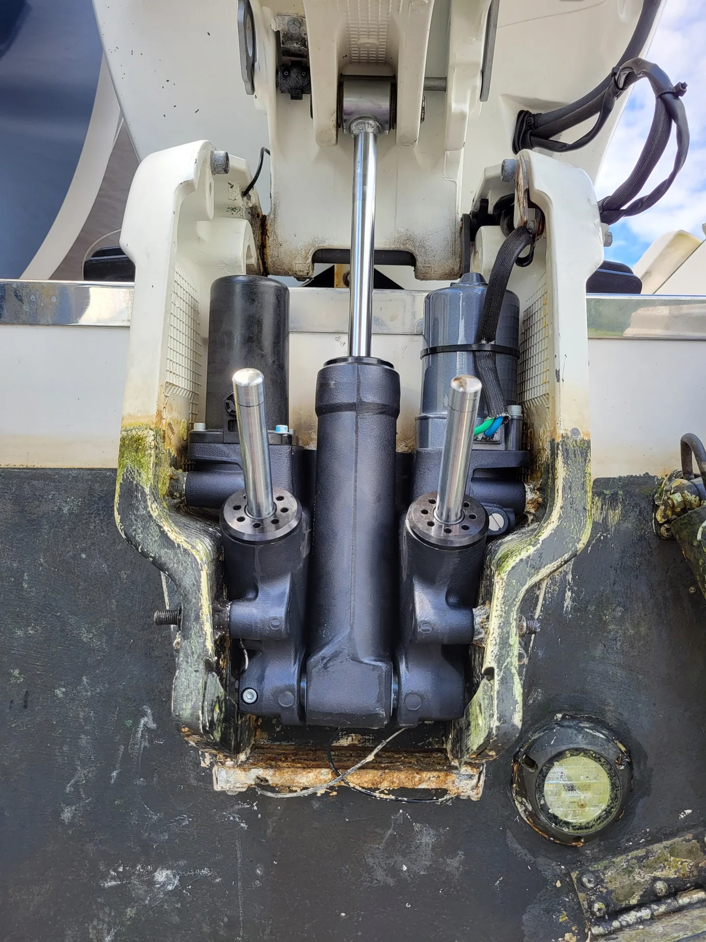Twin outboard tilt-and-trim hydraulic assemblies at a vessel transom