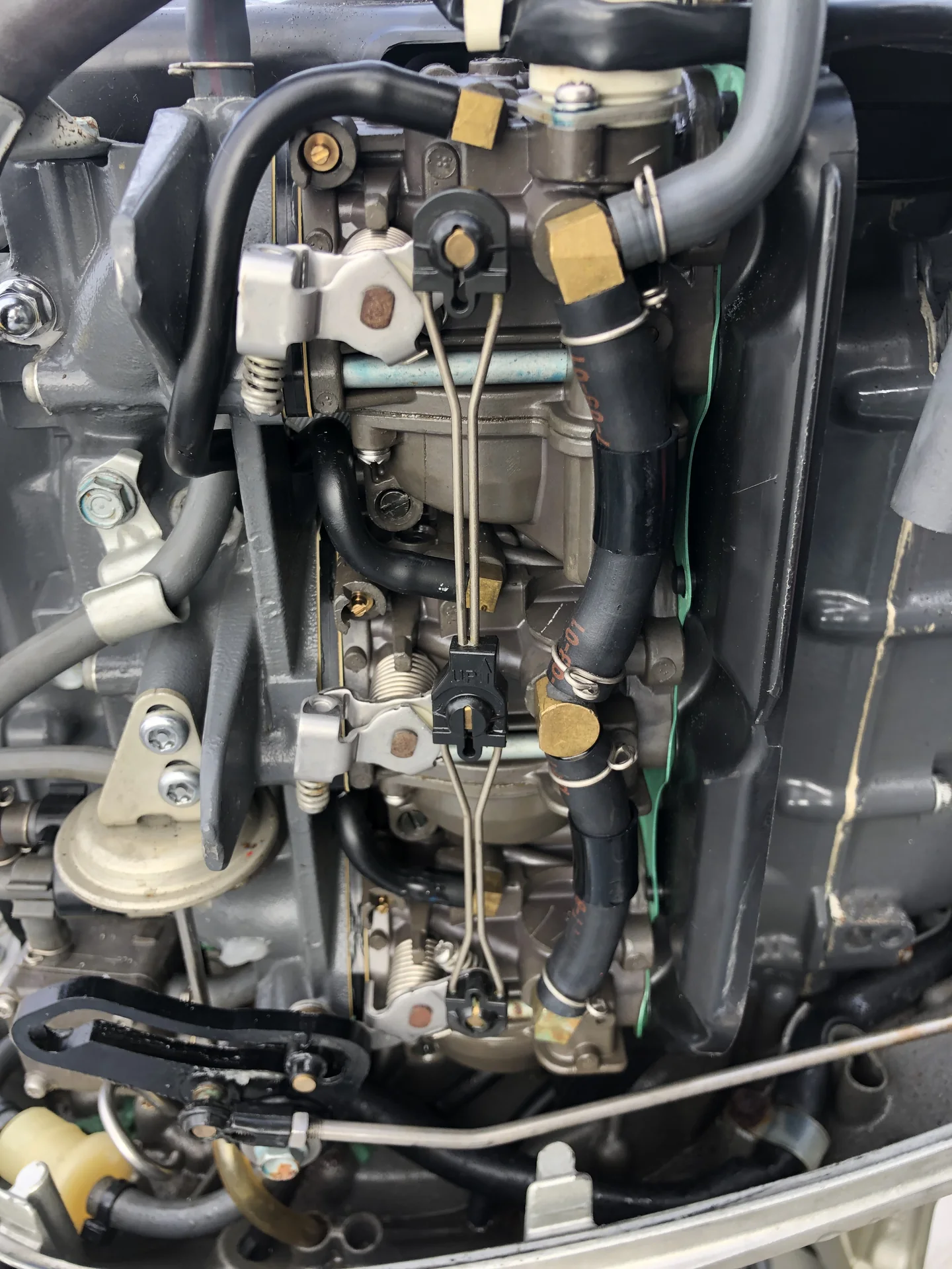 Marine outboard carburetor and linkage components exposed for inspection