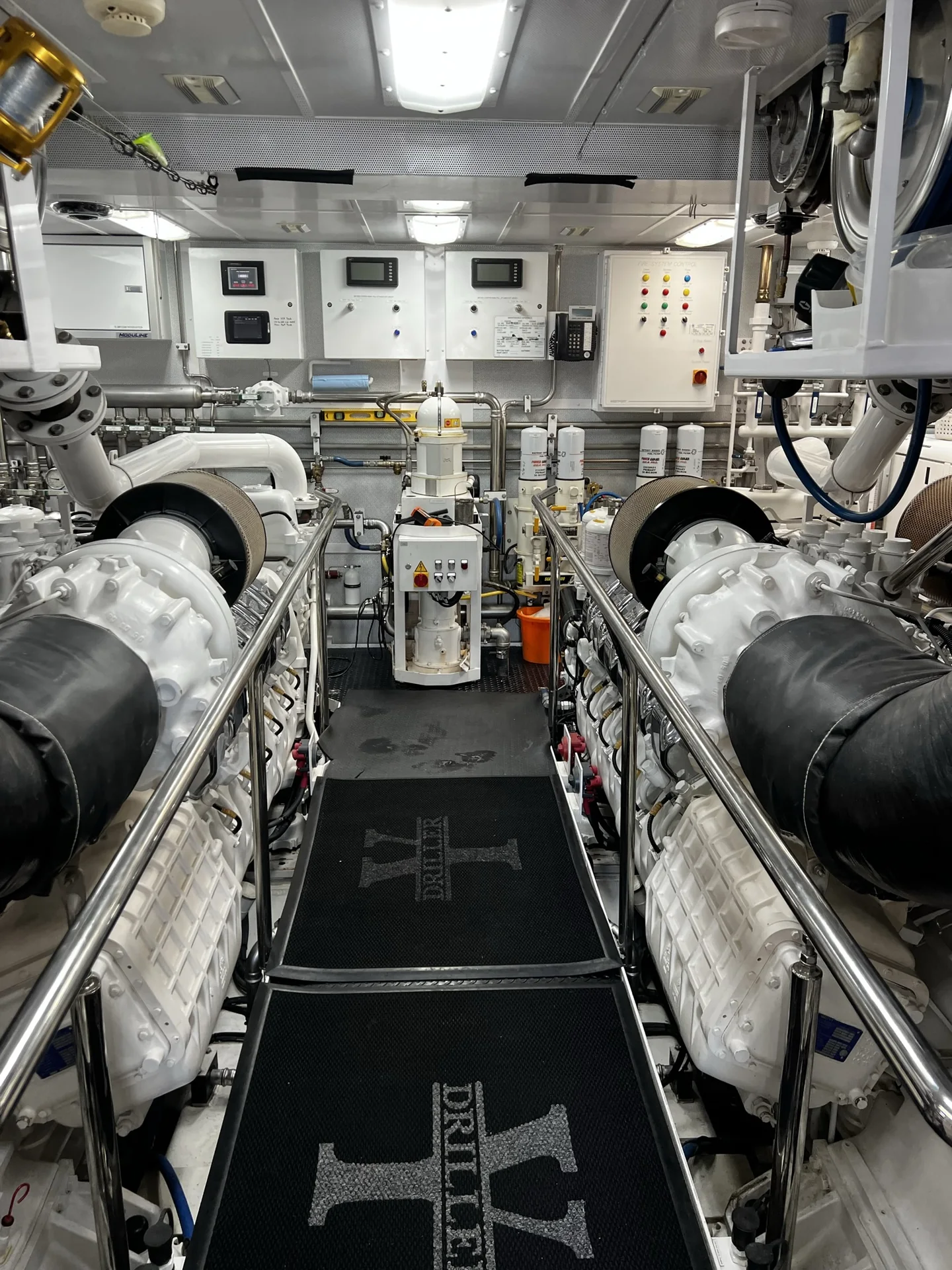 Clean marine engine room with twin diesel engines and centralized controls
