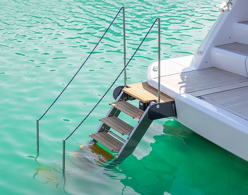 Electric boarding stairs extending from a yacht swim platform