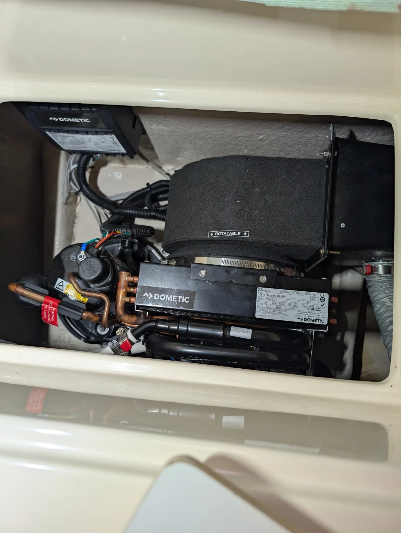 Dometic marine air-conditioning unit behind an onboard service opening