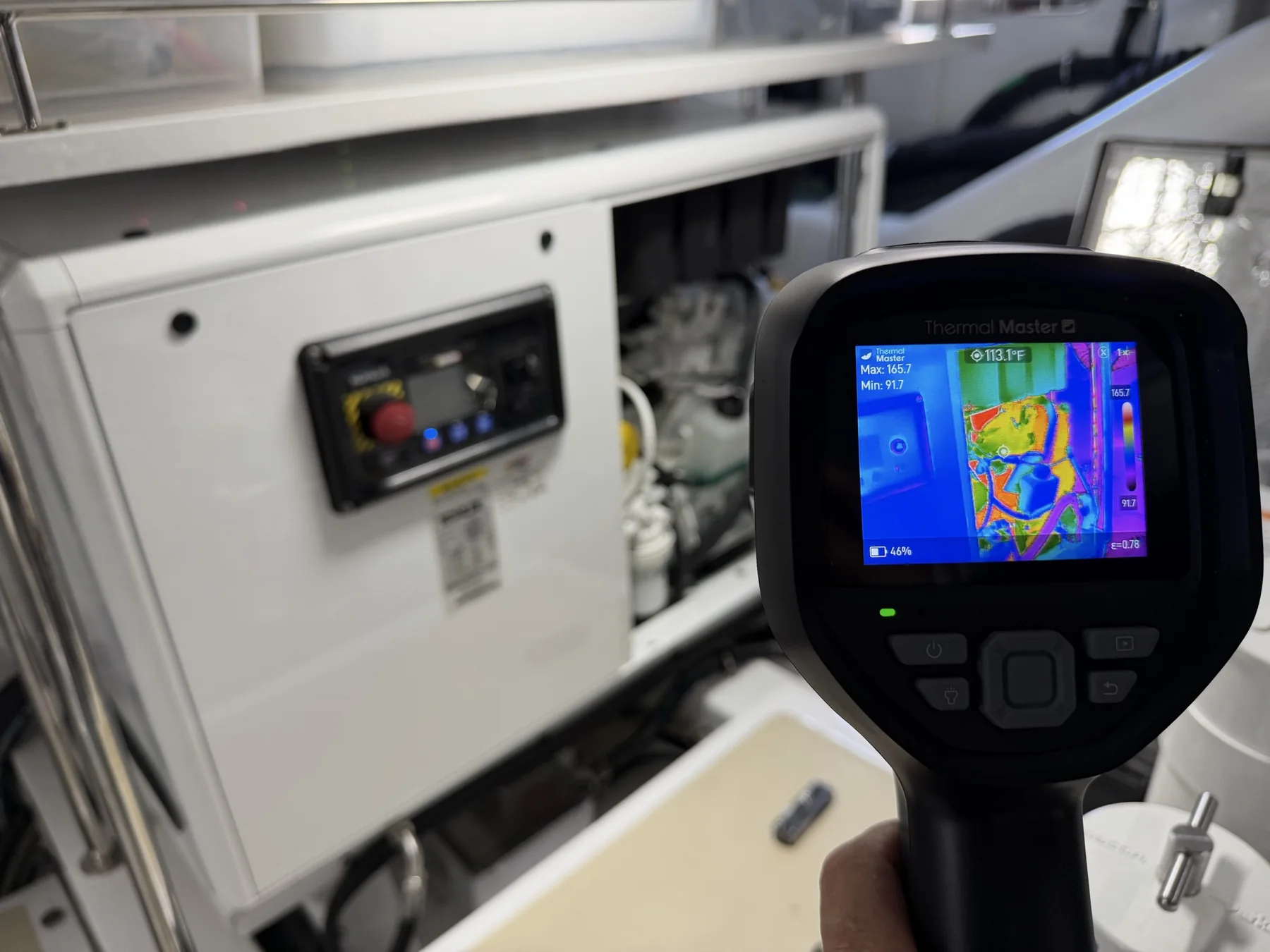 Handheld thermal imaging camera displaying a heat pattern at marine electrical equipment
