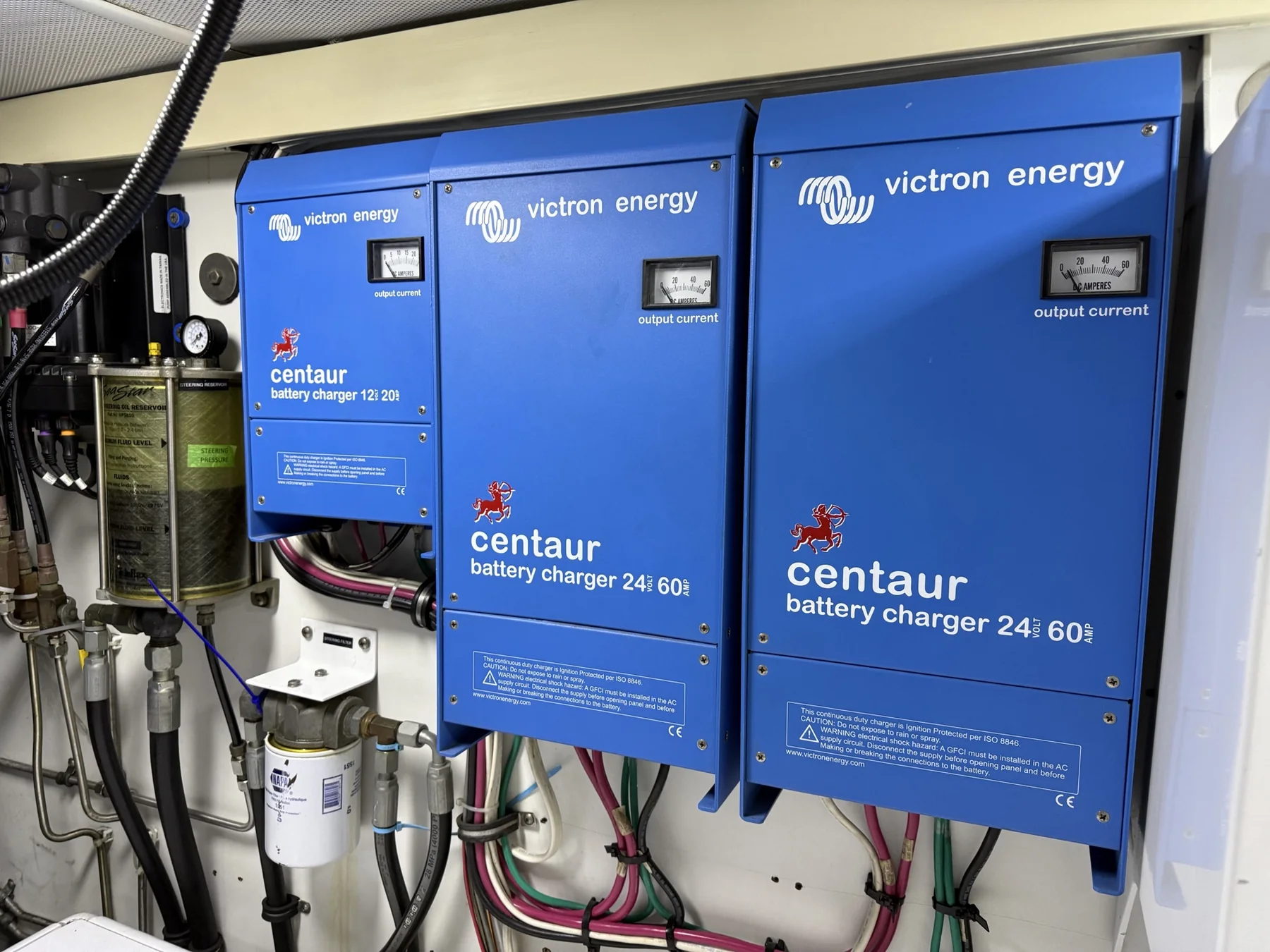 Three Victron Energy battery chargers mounted together with connected wiring