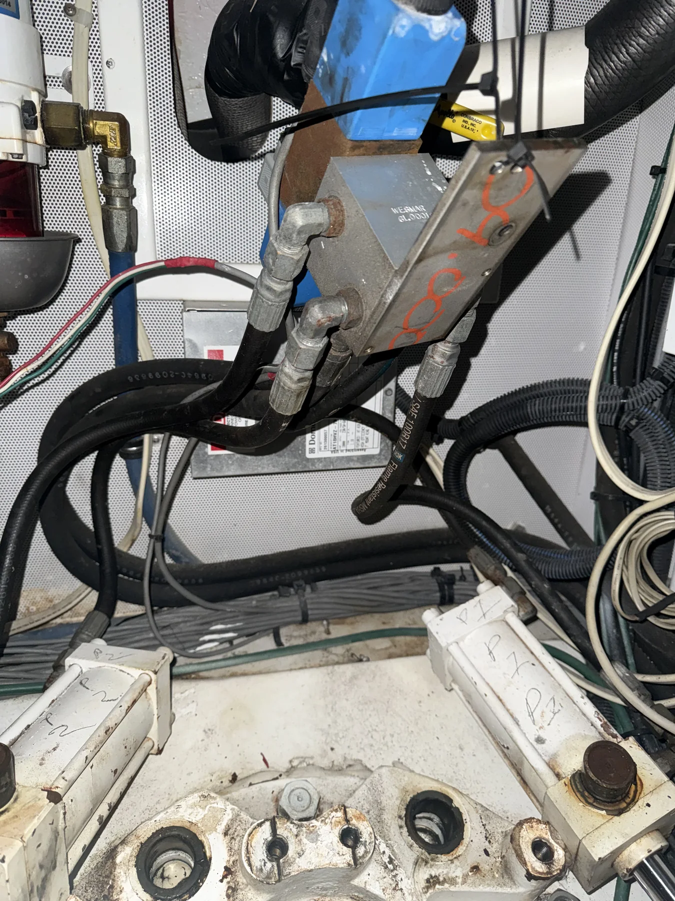 Marine hydraulic manifold with labeled circuits, hoses, and fittings.