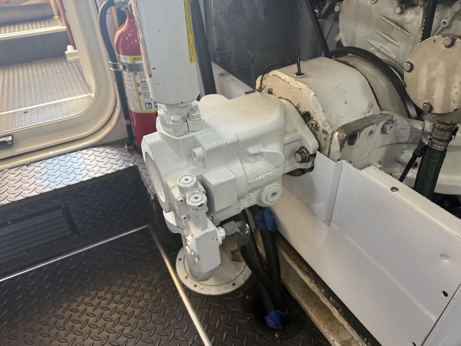 White engine-driven marine hydraulic pump assembly mounted in a machinery space