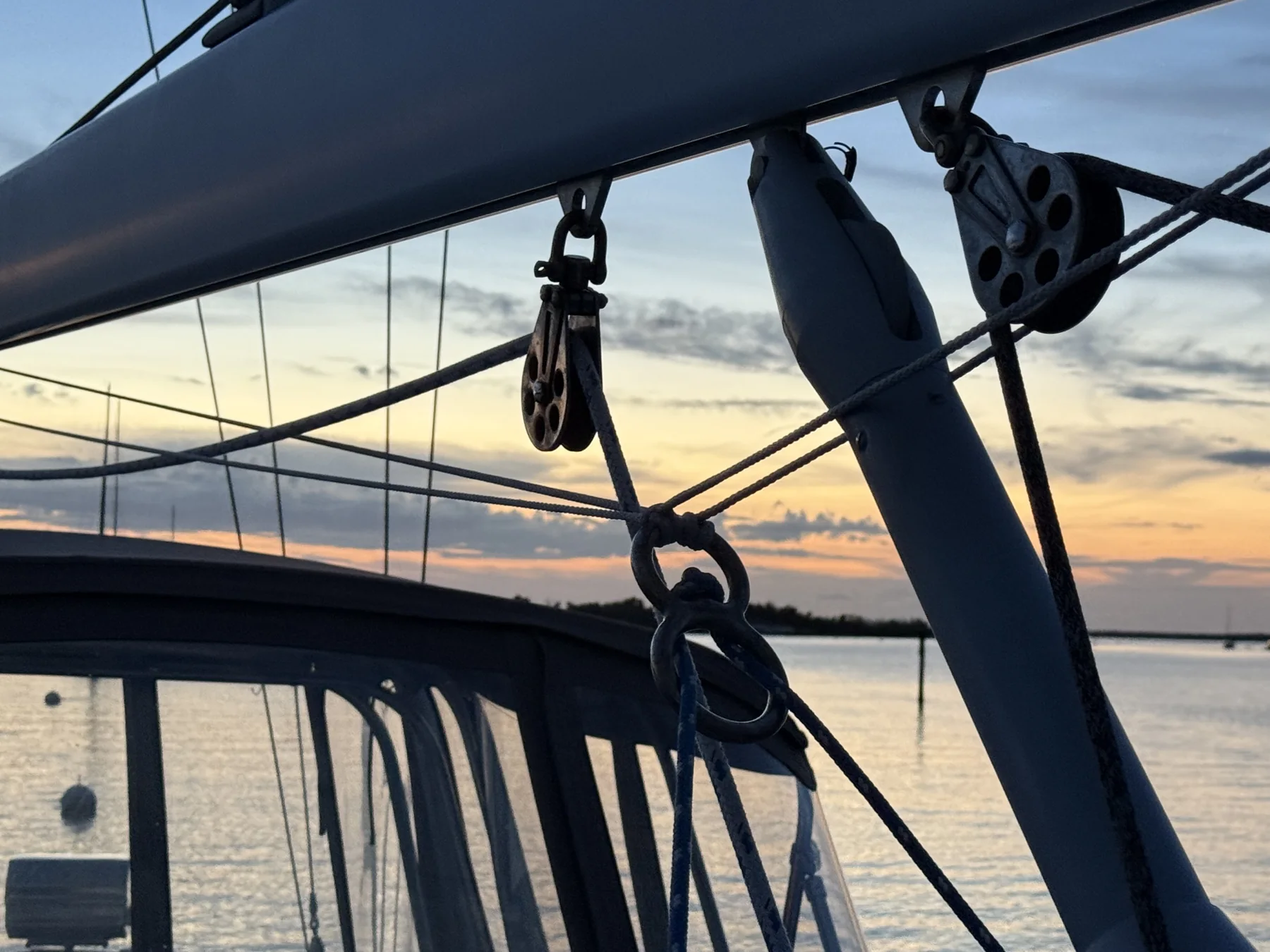 Sail-control blocks, low-friction rings, and lines attached to a sailboat boom