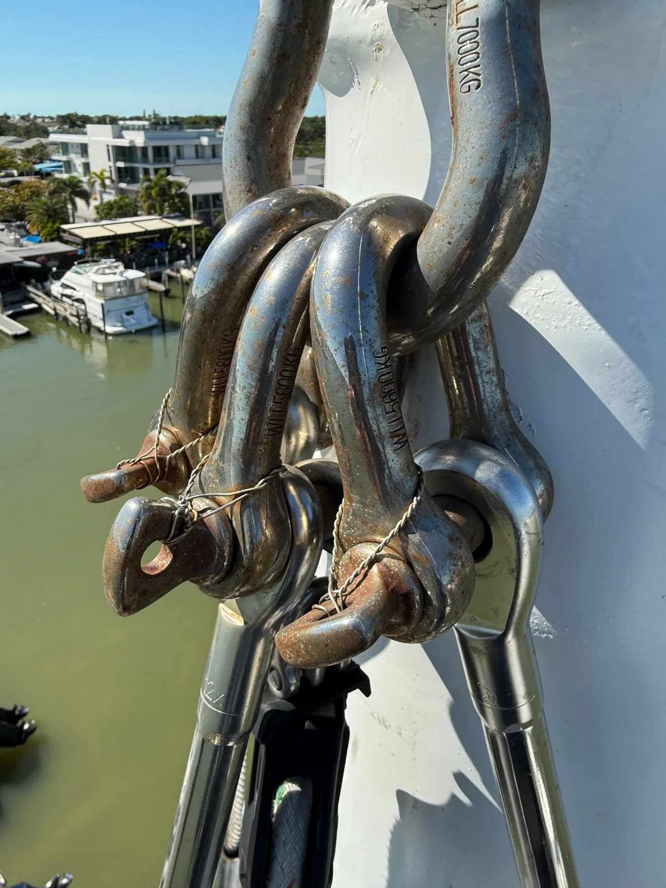 Metal shackles secured with safety wire at a sailboat mast rigging connection
