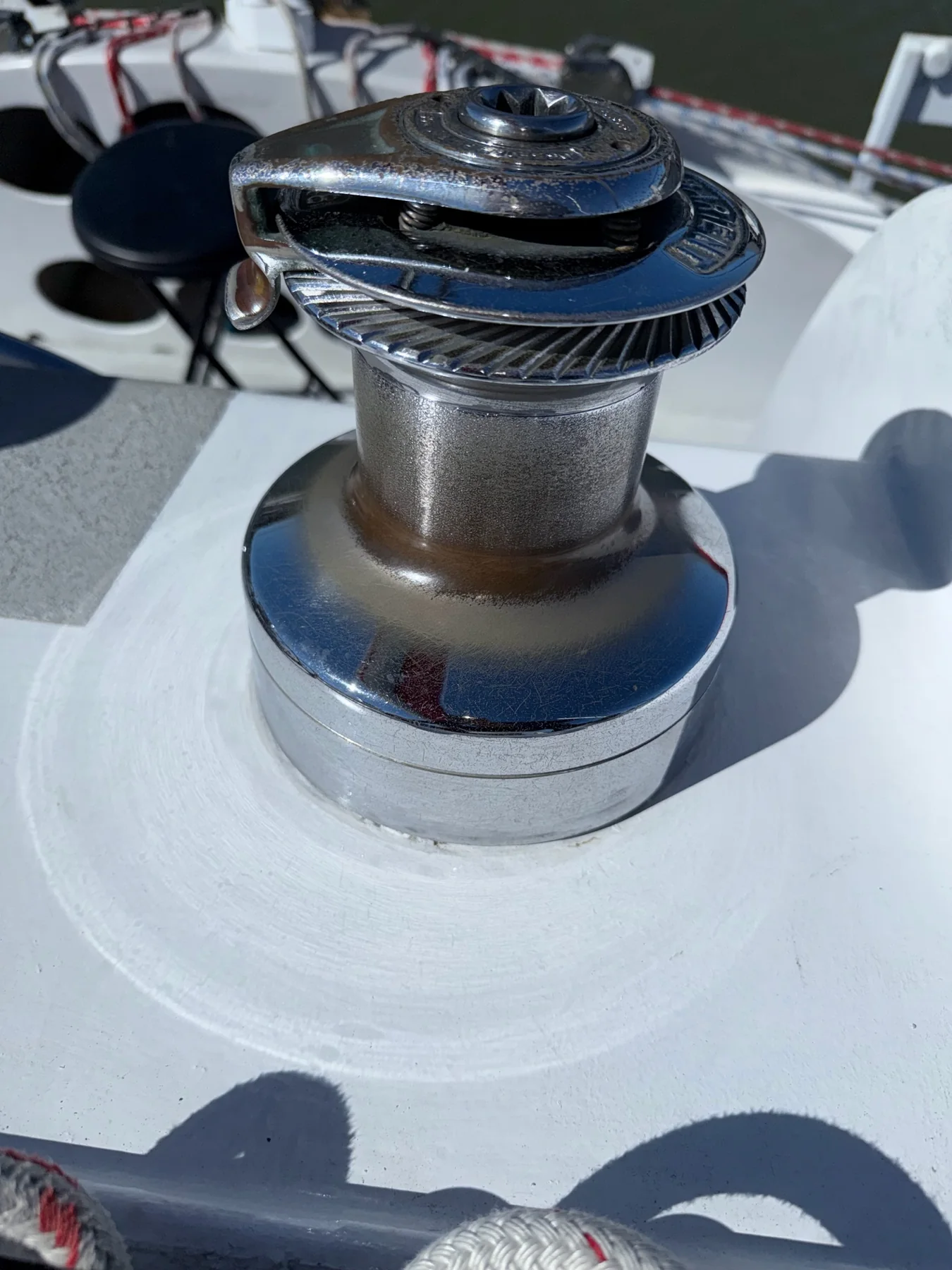 Stainless steel self-tailing winch installed on a white sailboat deck