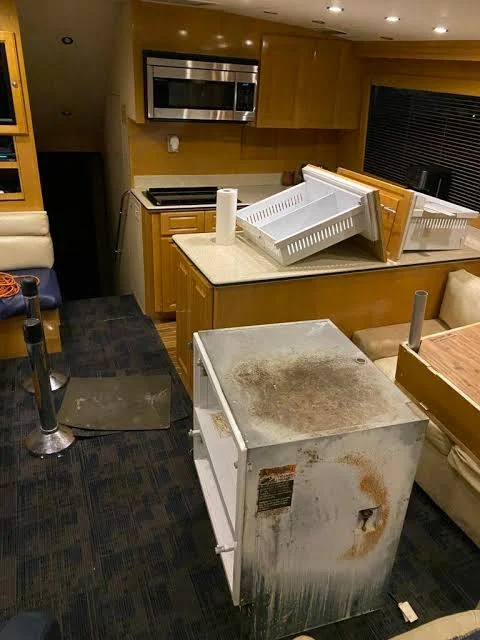 Removed refrigerator and freezer equipment inside a yacht interior during replacement work