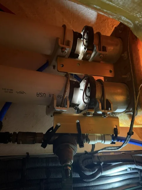Two mounted onboard pumps with connected plumbing and electrical leads